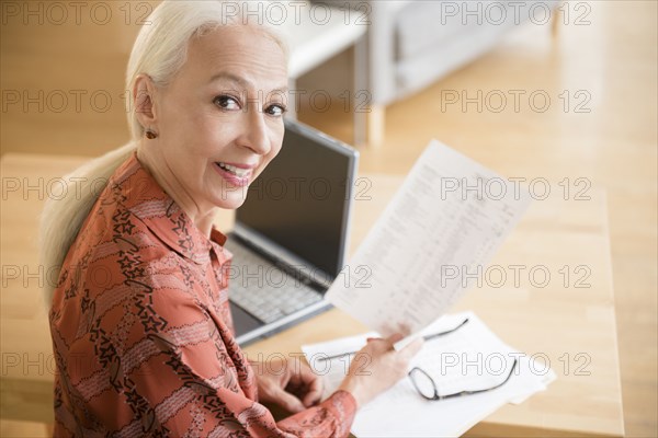 Caucasian woman paying bills on laptop