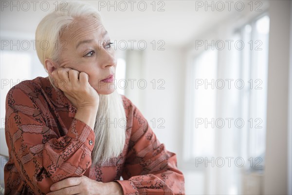 Caucasian woman sitting with chin in hand