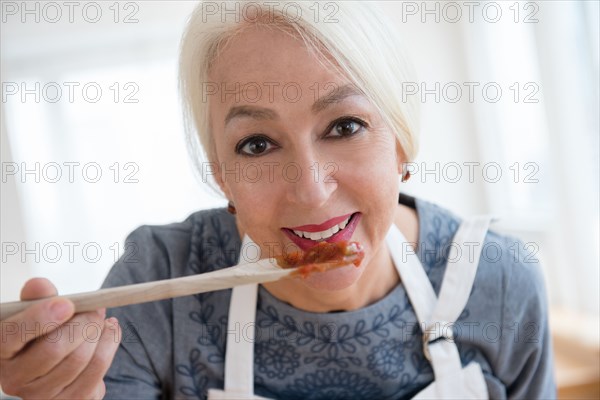 Caucasian woman tasting sauce