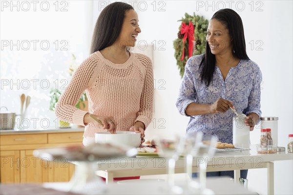 Mother and daughter baking in kitchen