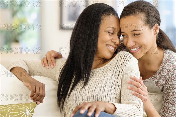 Mother and daughter hugging in living room