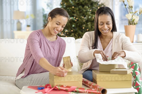 Mother and daughter wrapping Christmas gifts