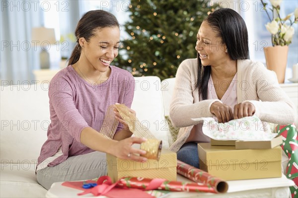 Mother and daughter wrapping Christmas gifts