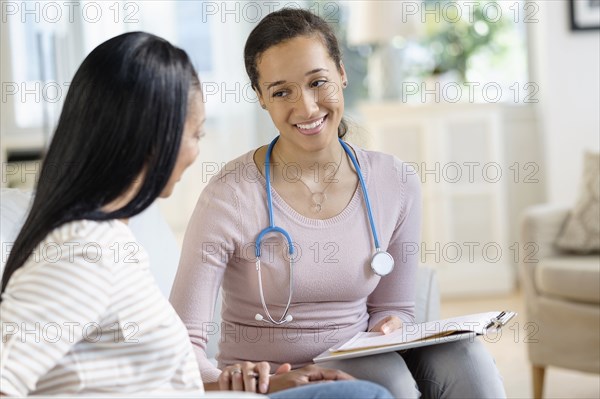 Doctor comforting patient in living room