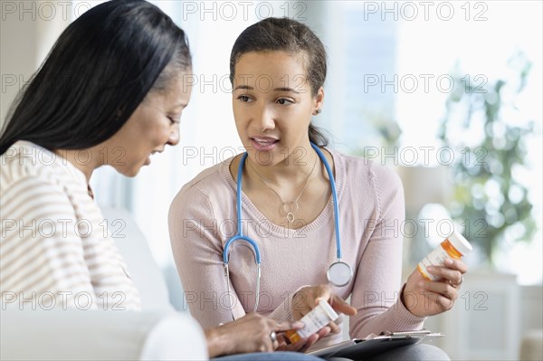 Doctor and patient discussing medication in living room