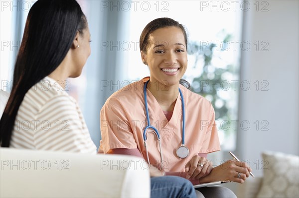 Nurse smiling with patient in living room