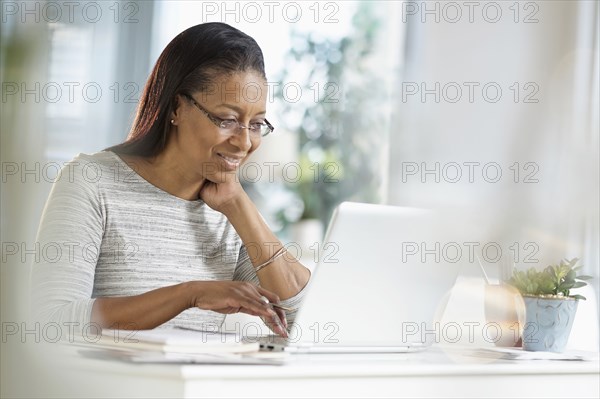 Mixed race woman using laptop