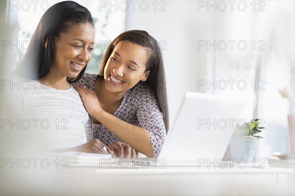 Mother and daughter using laptop