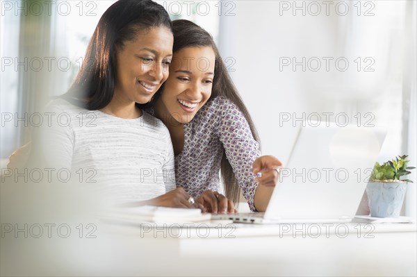 Mother and daughter using laptop