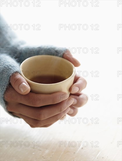 Hispanic woman holding cup of tea