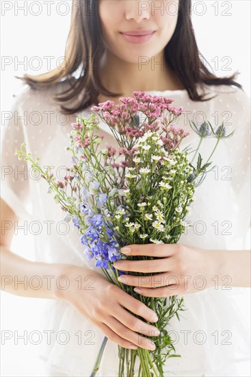 Hispanic woman holding bouquet of flowers