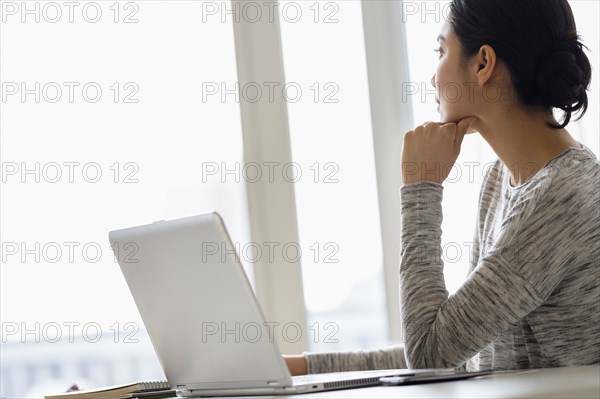 Hispanic woman sitting at laptop