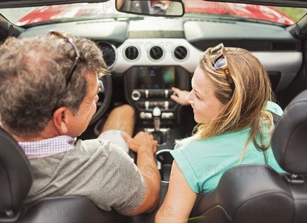 Caucasian couple driving convertible