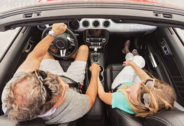 High angle view of Caucasian couple holding hands convertible