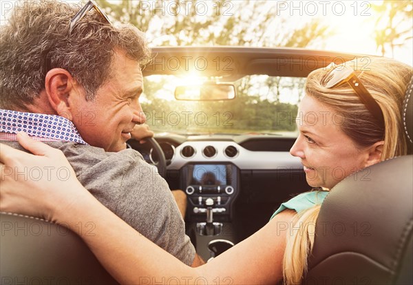 Caucasian couple driving convertible