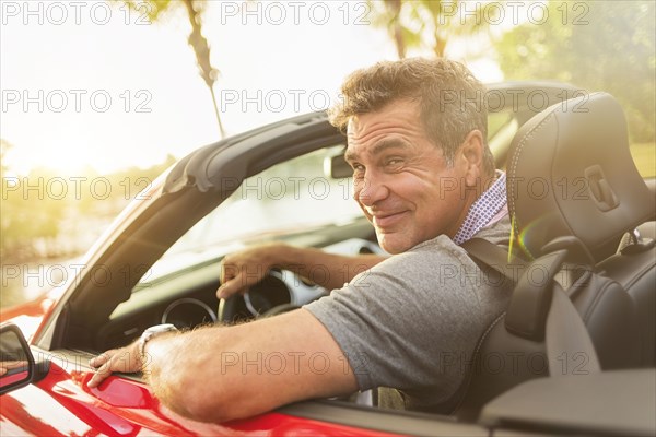 Caucasian man driving convertible