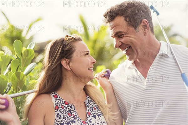 Caucasian couple playing miniature golf