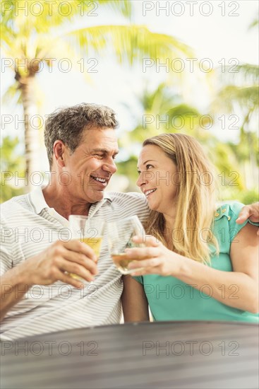 Caucasian couple toasting with wine outdoors