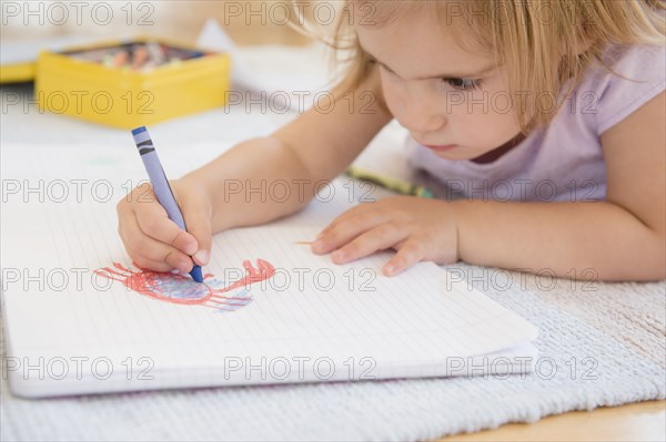 Caucasian girl drawing on floor