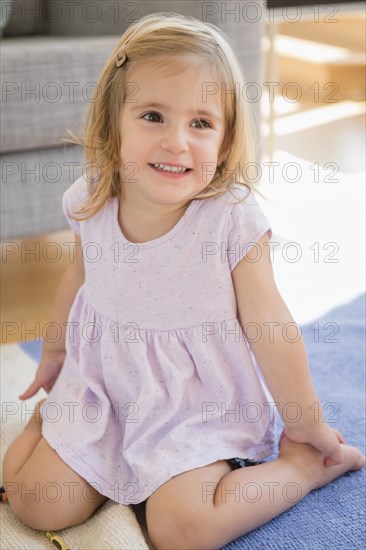 Caucasian girl sitting on floor