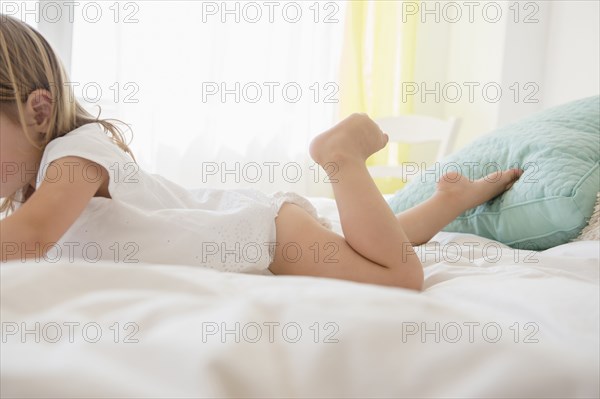Caucasian girl laying on bed