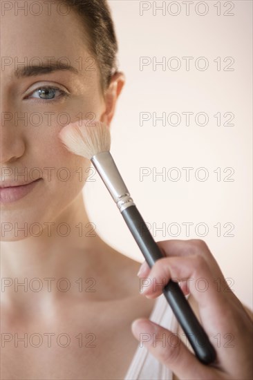 Woman having makeup applied by stylist