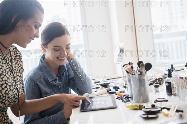 Makeup artist using digital tablet with client