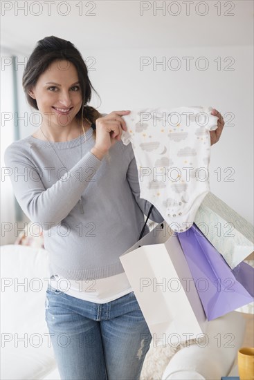 Pregnant Caucasian woman shopping for baby clothing