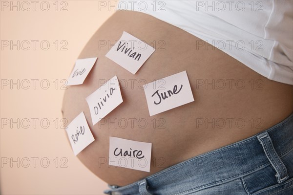 Pregnant Caucasian woman with name suggestions on belly