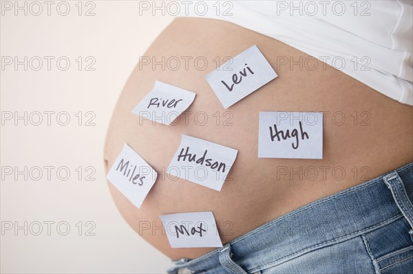 Pregnant Caucasian woman with name suggestions on belly