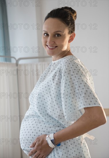 Pregnant Caucasian woman wearing hospital gown