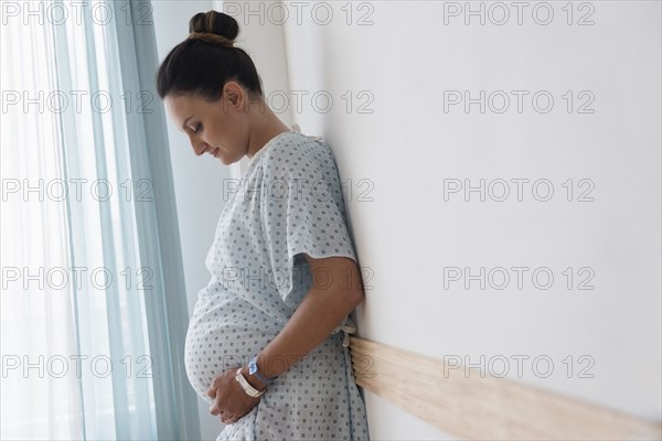 Pregnant Caucasian woman wearing hospital gown