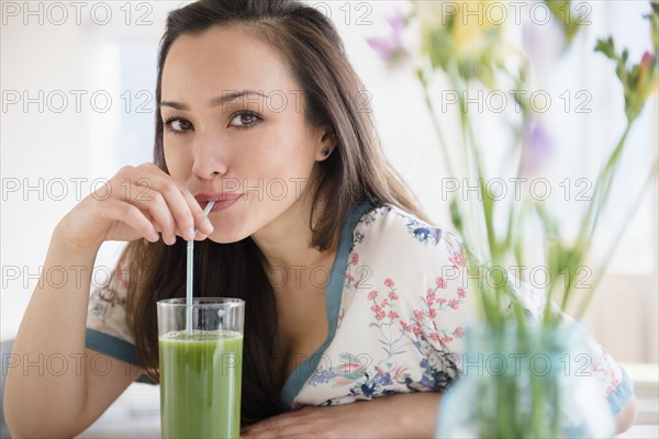 Woman drinking green juice