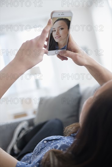 Woman taking selfie on sofa