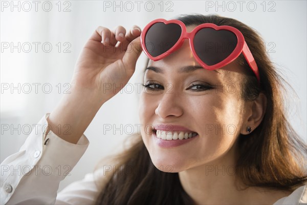 Smiling woman wearing heart shaped sunglasses