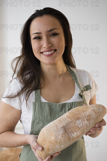 Baker holding loaf of bread