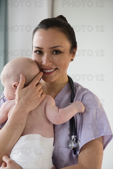 Nurse holding baby in hospital