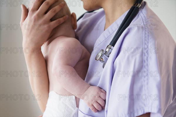 Nurse holding baby in hospital