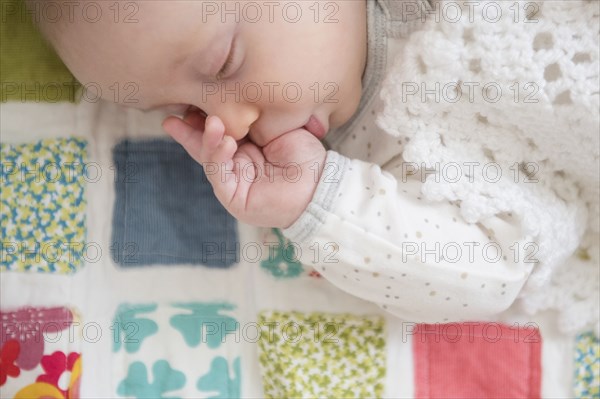 Sleeping Caucasian baby sucking thumb