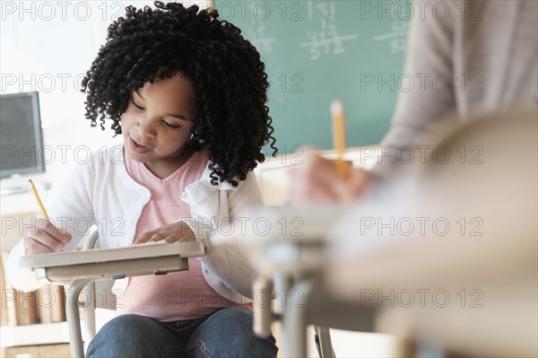 African American student writing in classroom