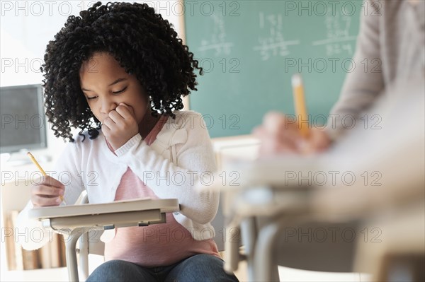 African American student writing in classroom