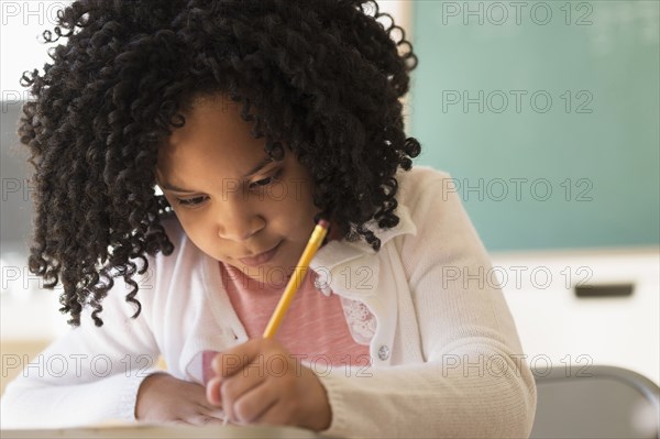 African American student writing in classroom