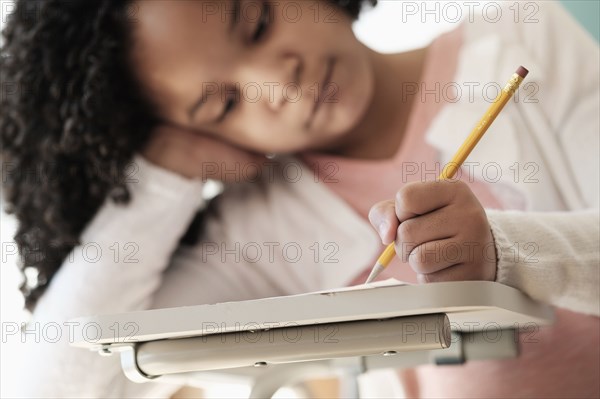 African American student writing in classroom