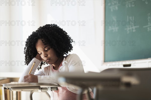 African American student writing in classroom