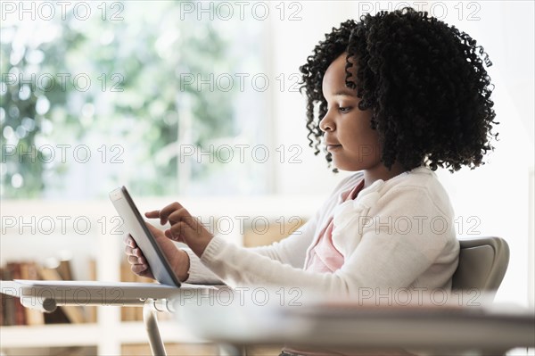African American student using digital tablet in classroom