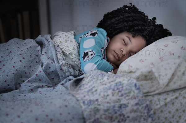 African American girl sleeping in bed