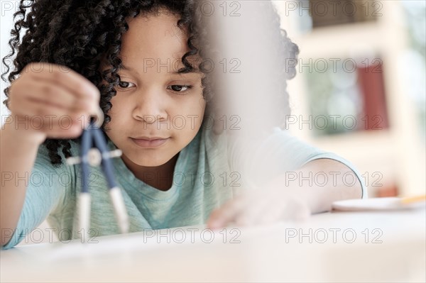 African American girl using compass in science classroom