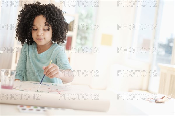 African American girl painting with watercolors