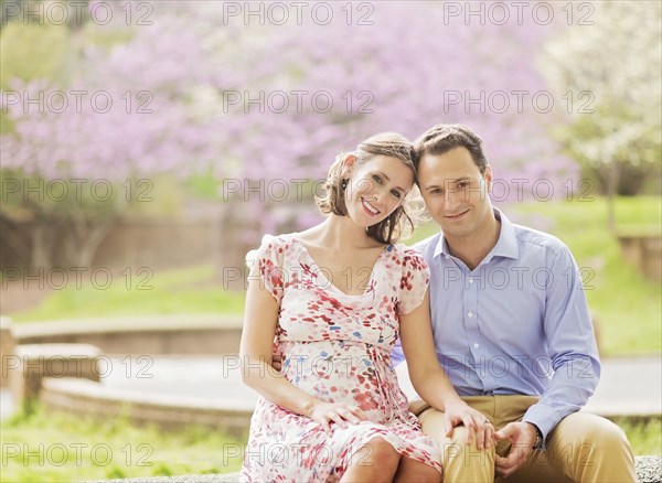 Pregnant Caucasian couple smiling outdoors