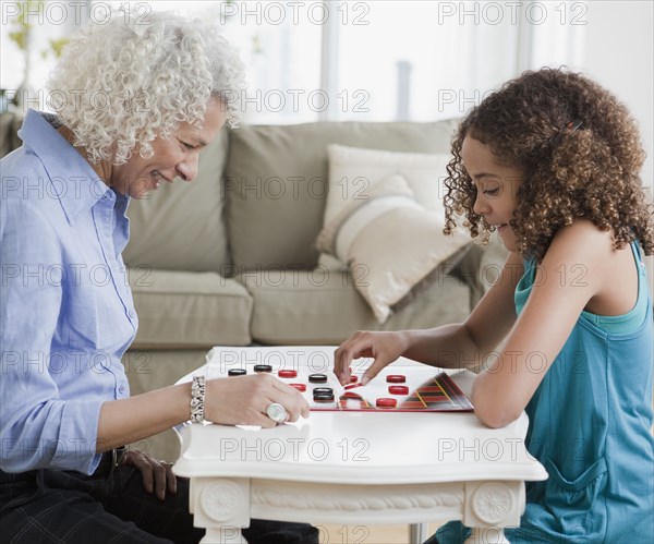 Grandmother and granddaughter playing checkers